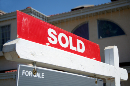 House with "sold" sign in the yard